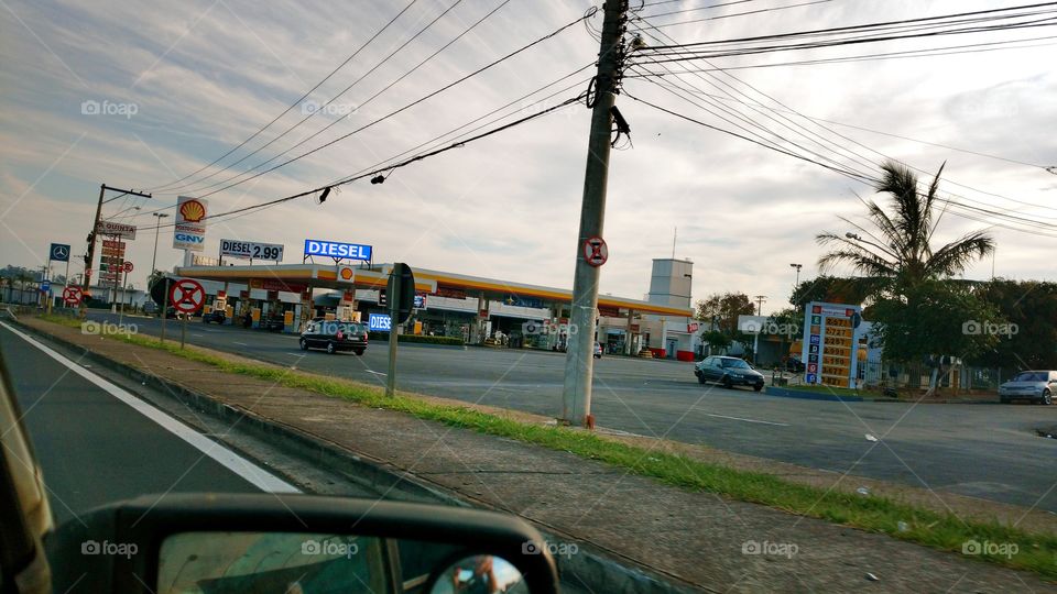 Dirigindo em viagem com veículo velho na estrada, danificado, com painel ruim, acabado, desmanchado, quebrado. Situação financeira. Posto de gasolina.