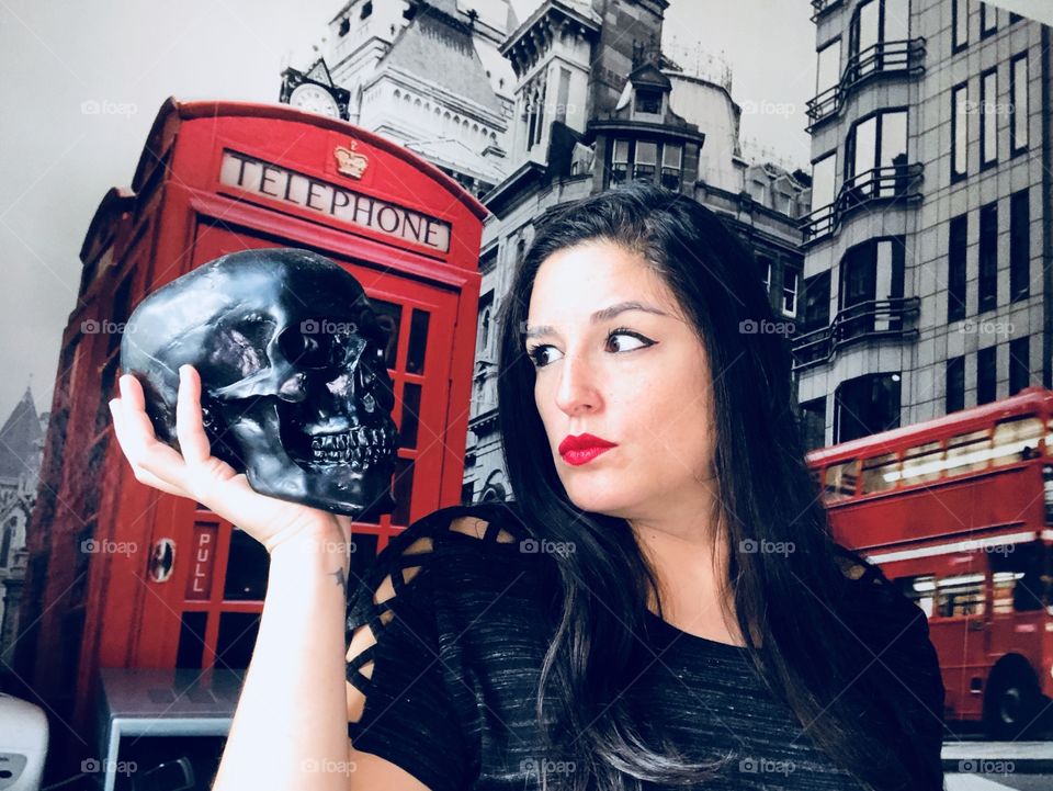 Woman holding a skull with London on background 
