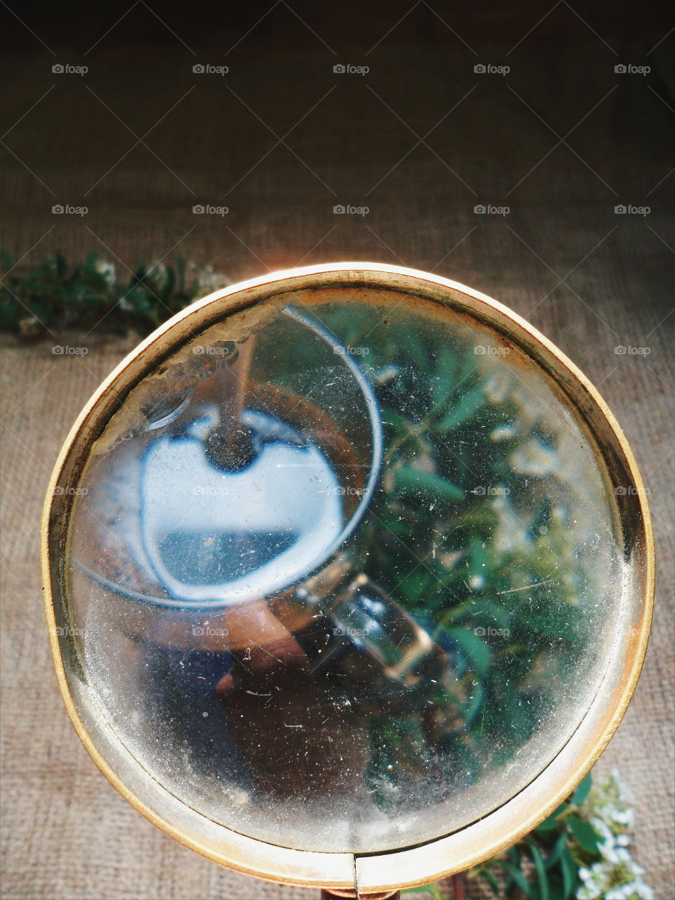 Cup of coffee and a bouquet of flowers under a magnifying glass