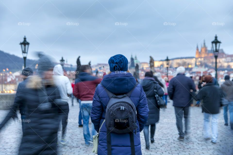 Woman walks between crowd of people in Prague