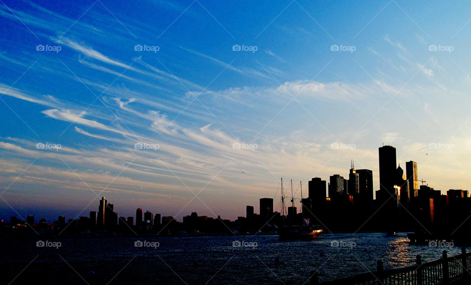 Blue Sky and Big City 2. Looking out at a city shoreline from the pier during sunset.