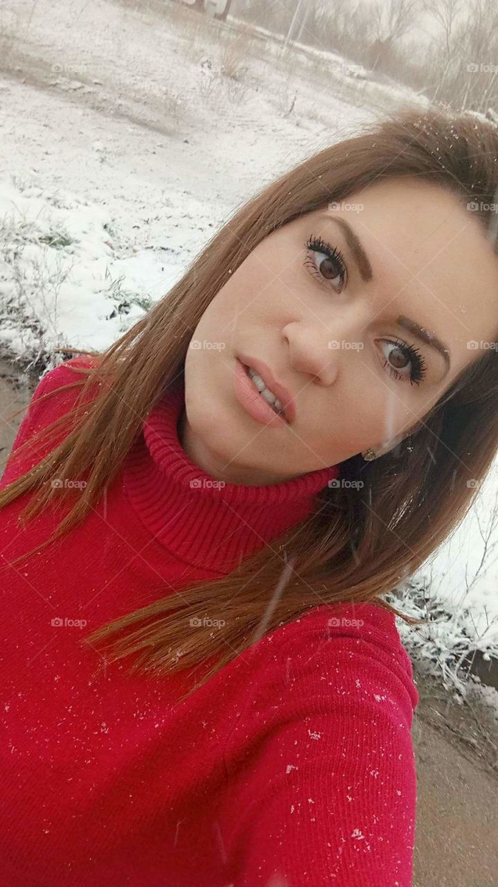 A beautiful woman taking a selfie in a winter landscape.
