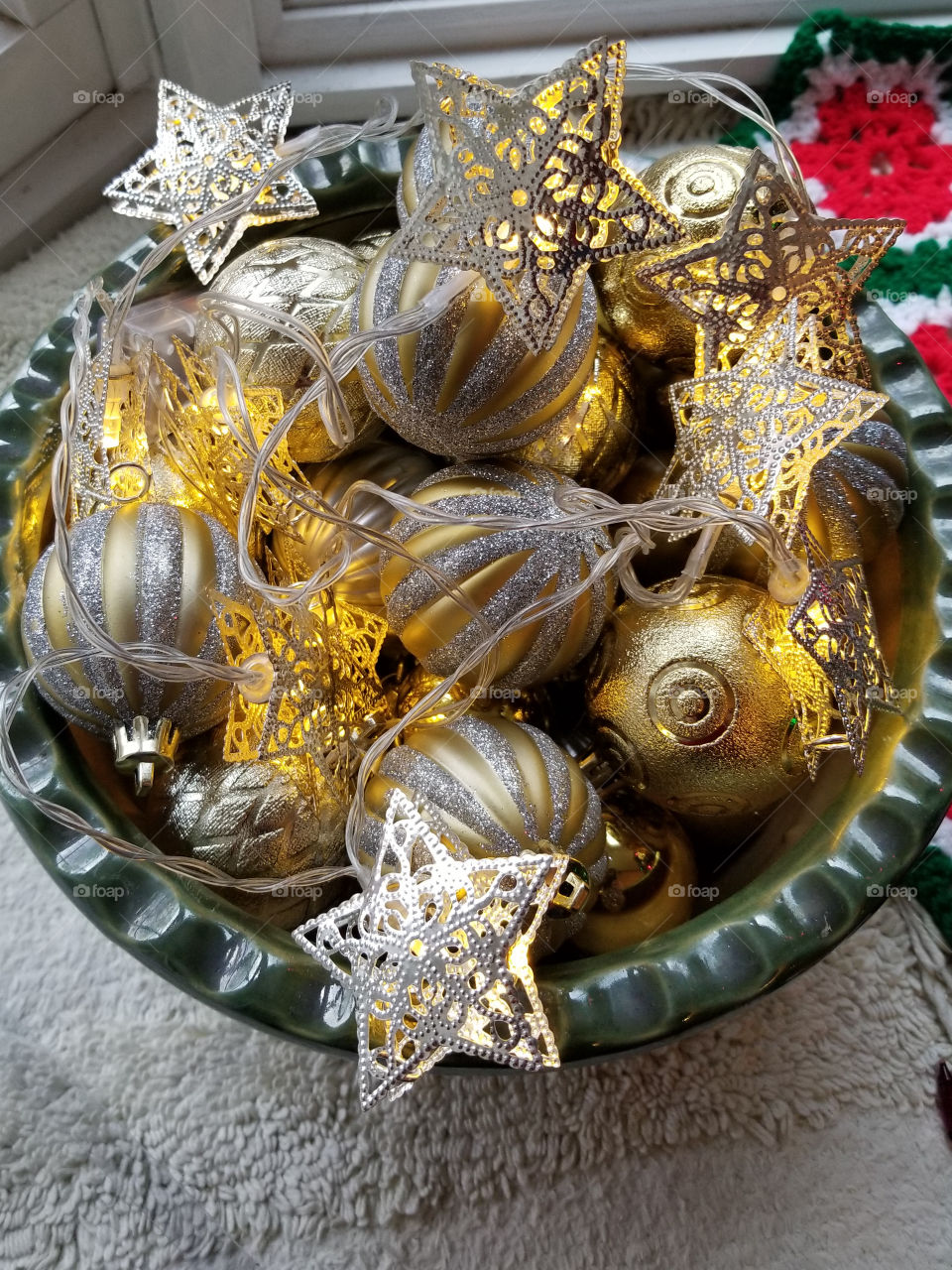 A bowl of festive Christmas ornaments and lights decorating a countertop.