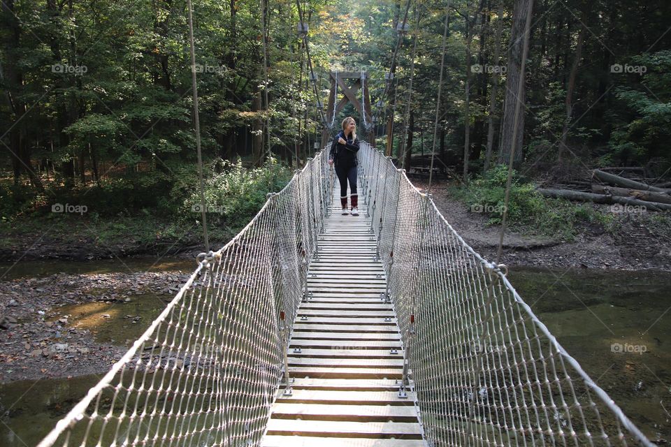 Woman hiking on bridge with back pack