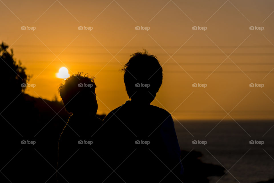 2 boys staring at a beautiful sunset