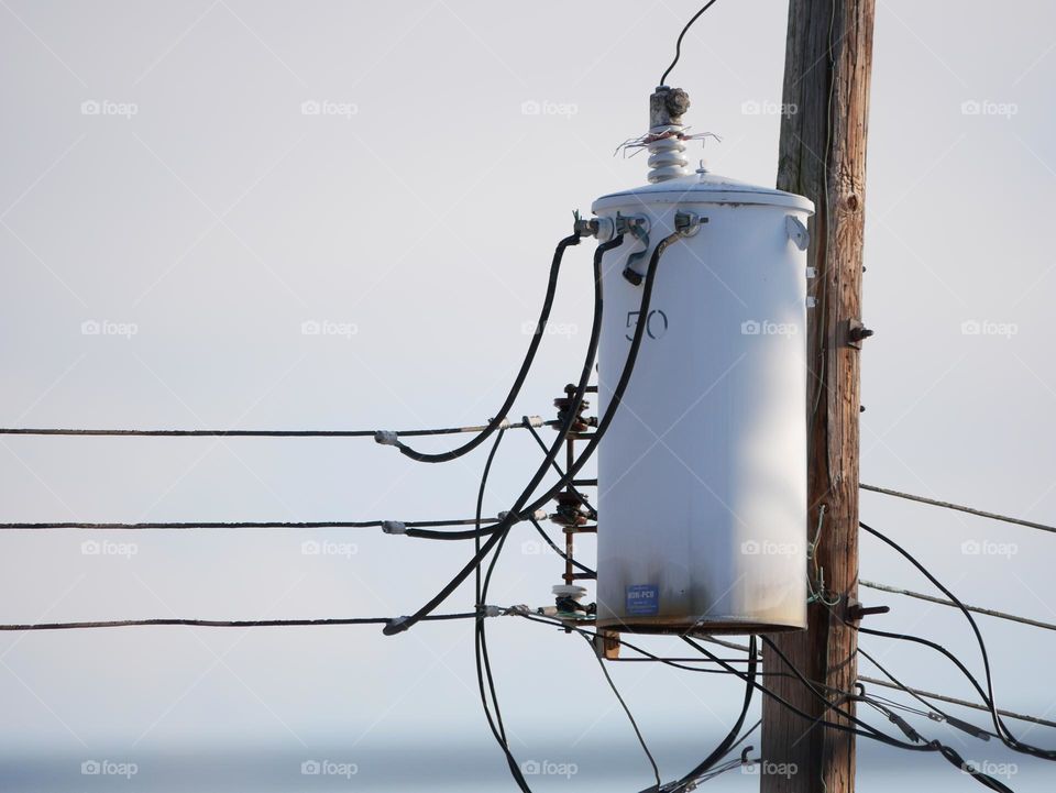 A transformer, high up on a utility pole. 