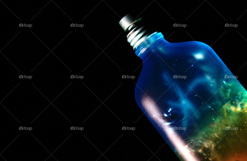 Blue bottle against black background