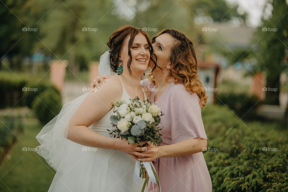 a happy moment of two childhood friends during a wedding and a sweet kiss
