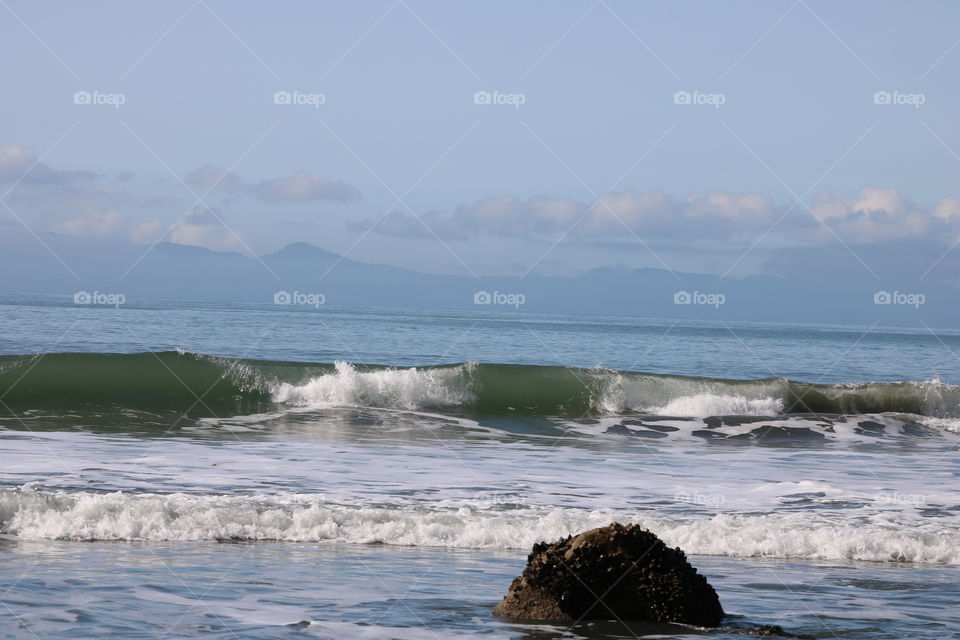 Big waves crashing on the shore on a sunny spring day