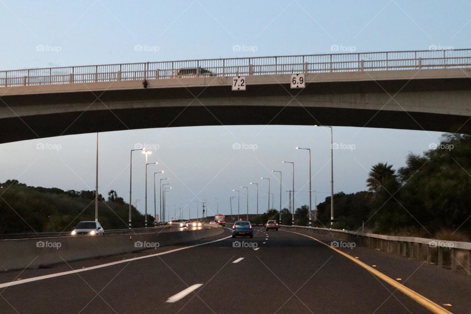 Cars on the road and the bridge above it