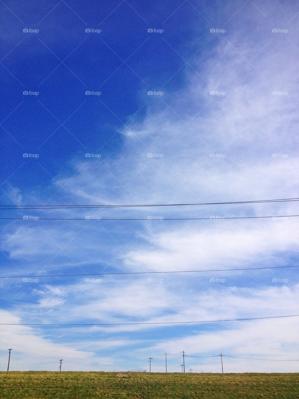 Lonely phone and power lines on a sunny bright clear day