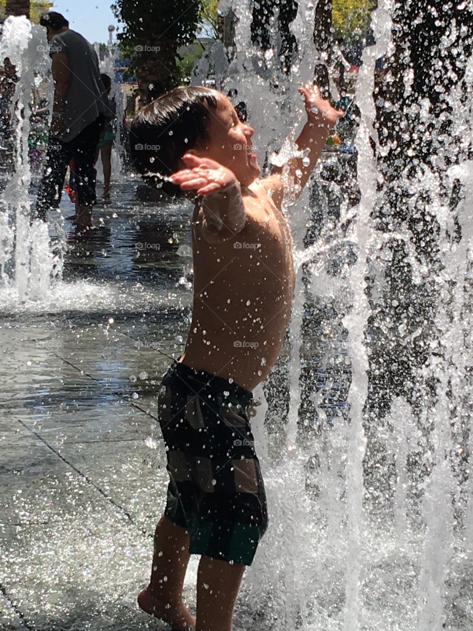 Little boy playing in a splash pad.