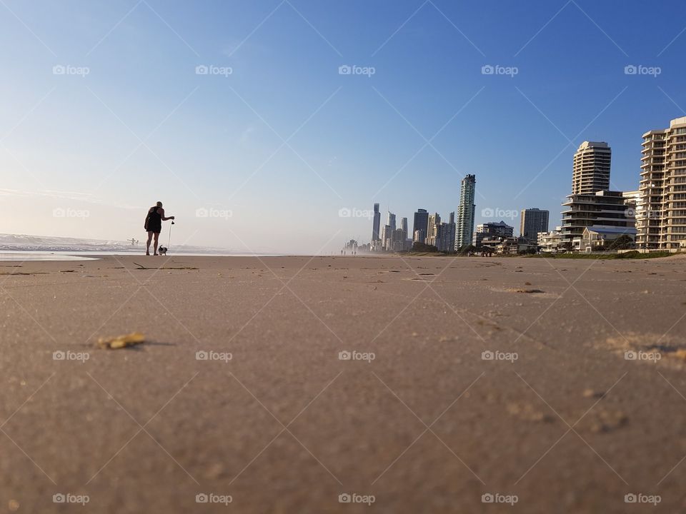 Walking puppy along beach at sunrise