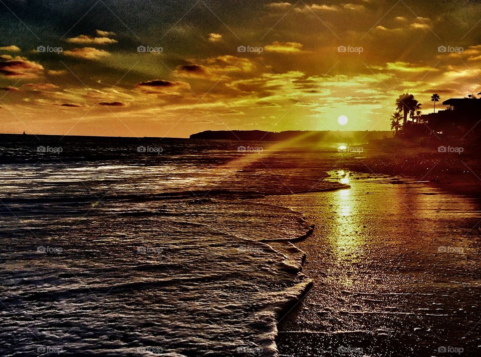 Sunlight reflecting on sand with dramatic sky