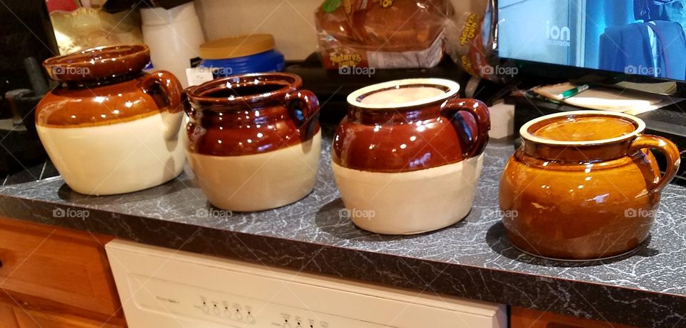 #clash of colour! Collection of brown antique bean pots on black counter in kitchen.