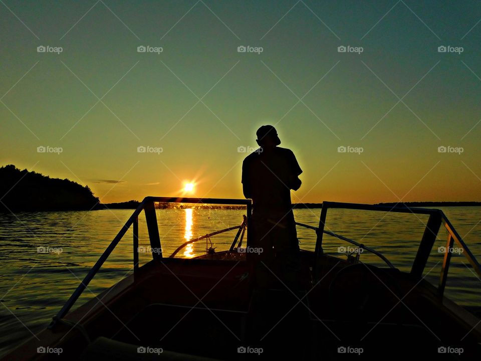 A fisherman is making his last cast of the day as the sunset descends below the horizon. The awesome beauty of the setting sun is also symbolic of the beauty and mystery of life itself.