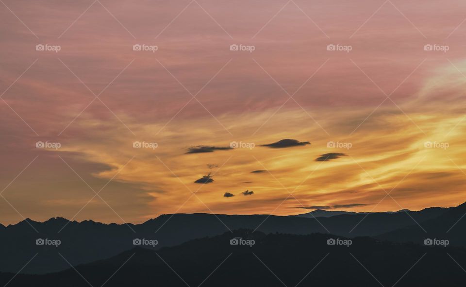 The mountain ranges backlite by the light of dawn, indicating the beginning of a new day