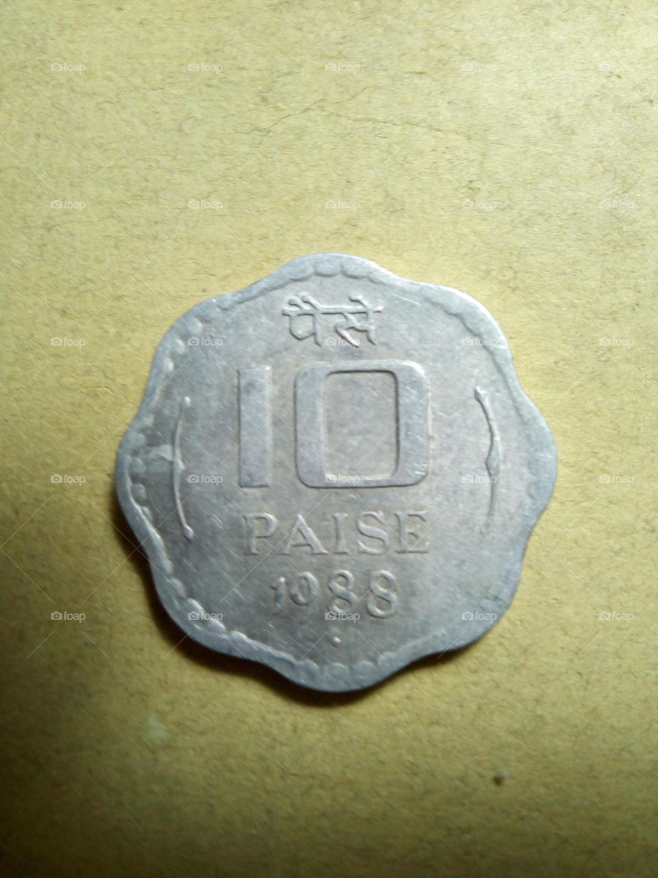 A coin of ten paise- 1/10 share of Indian Rupee issued by Government of India in 1988.
