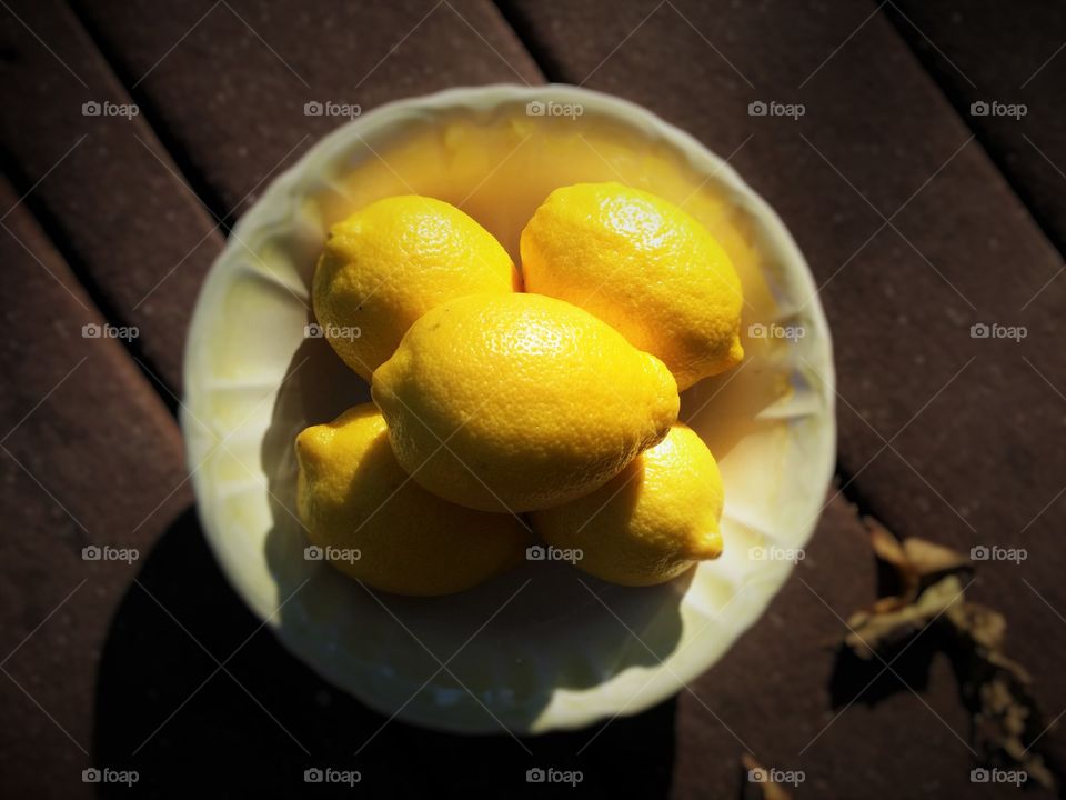 Bowl of lemons on a porch outside