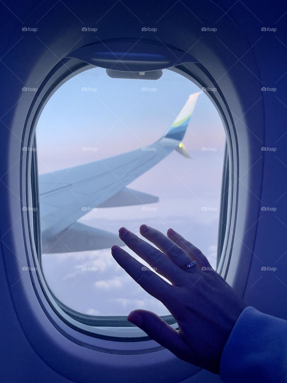 Female hand on the airplane window 