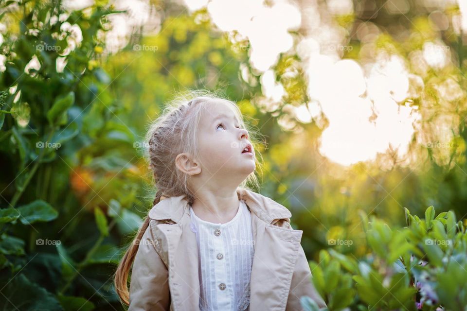 Candid lifestyle portrait of cute little Caucasian girl with surprised face