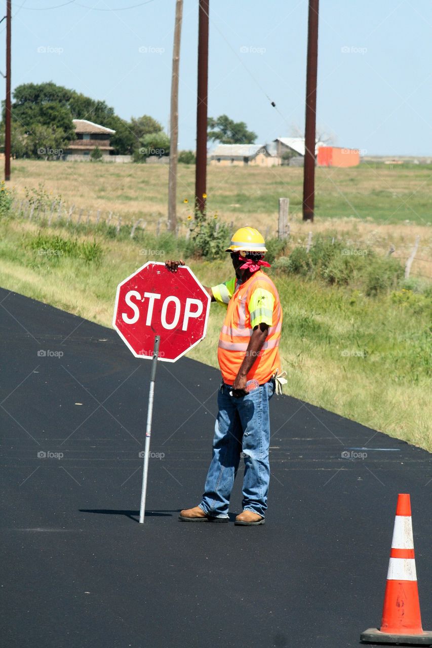 Man holding stop sign on road