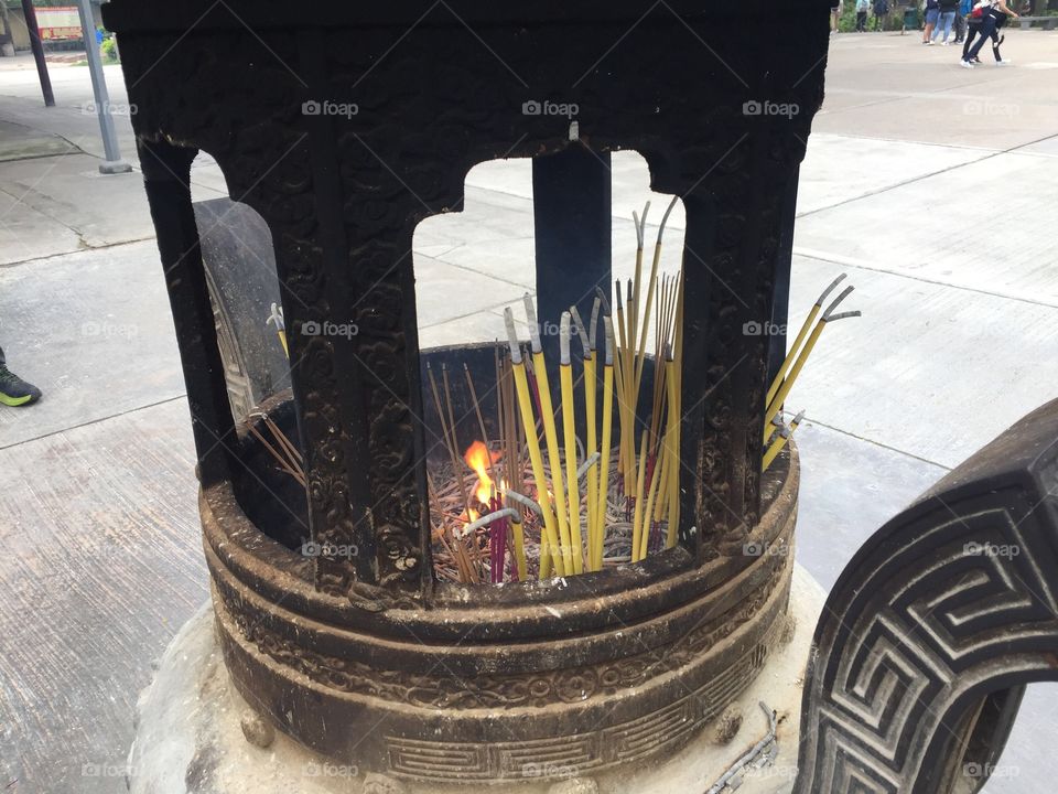 Buddhist Prayers to Buddha, by lighting incense, and letting their smokey prayers float to Buddha. Ancient Pottery-Ngong Ping Village, Po Lin Monastery, Lantau Island, Hong Kong. 
