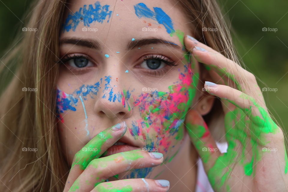 My daughter expressing her love of art and creativity. She splashed and brushed bright colorful paint on herself for her senior photo shoot. 