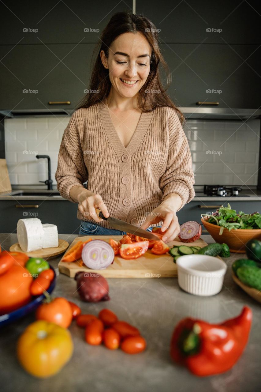 Woman cooking a healthy meal using colorful veggies.