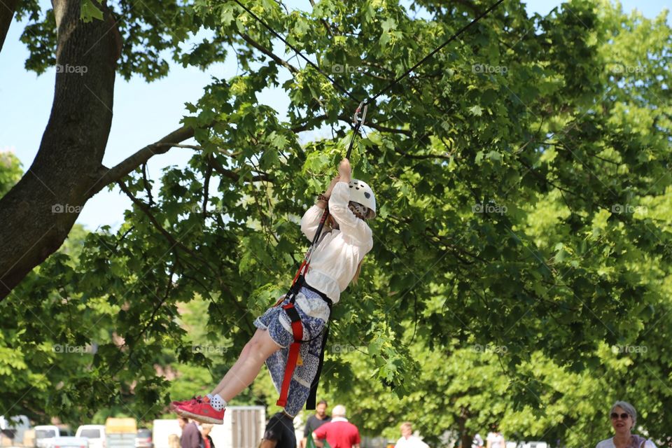 Child having fun on a wire in a tree