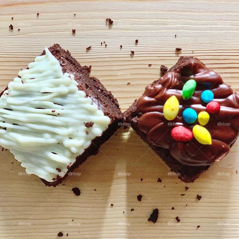 Home baked brownies in white chocolate drizzle and M&Ms sprinkles 