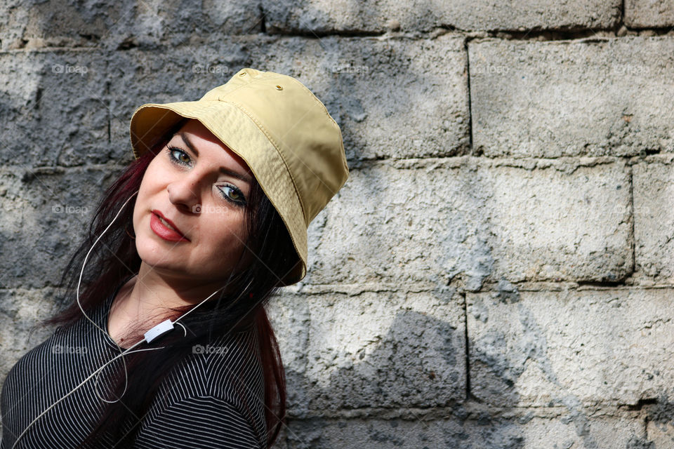 Girl with yellow hat listening to music