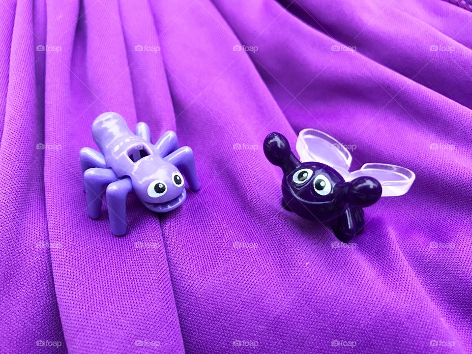 Two purple bug toy enjoy walking on the purple carpet