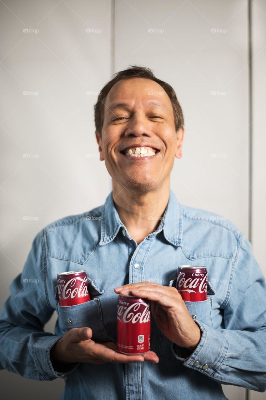 Man holding coke soda cans 