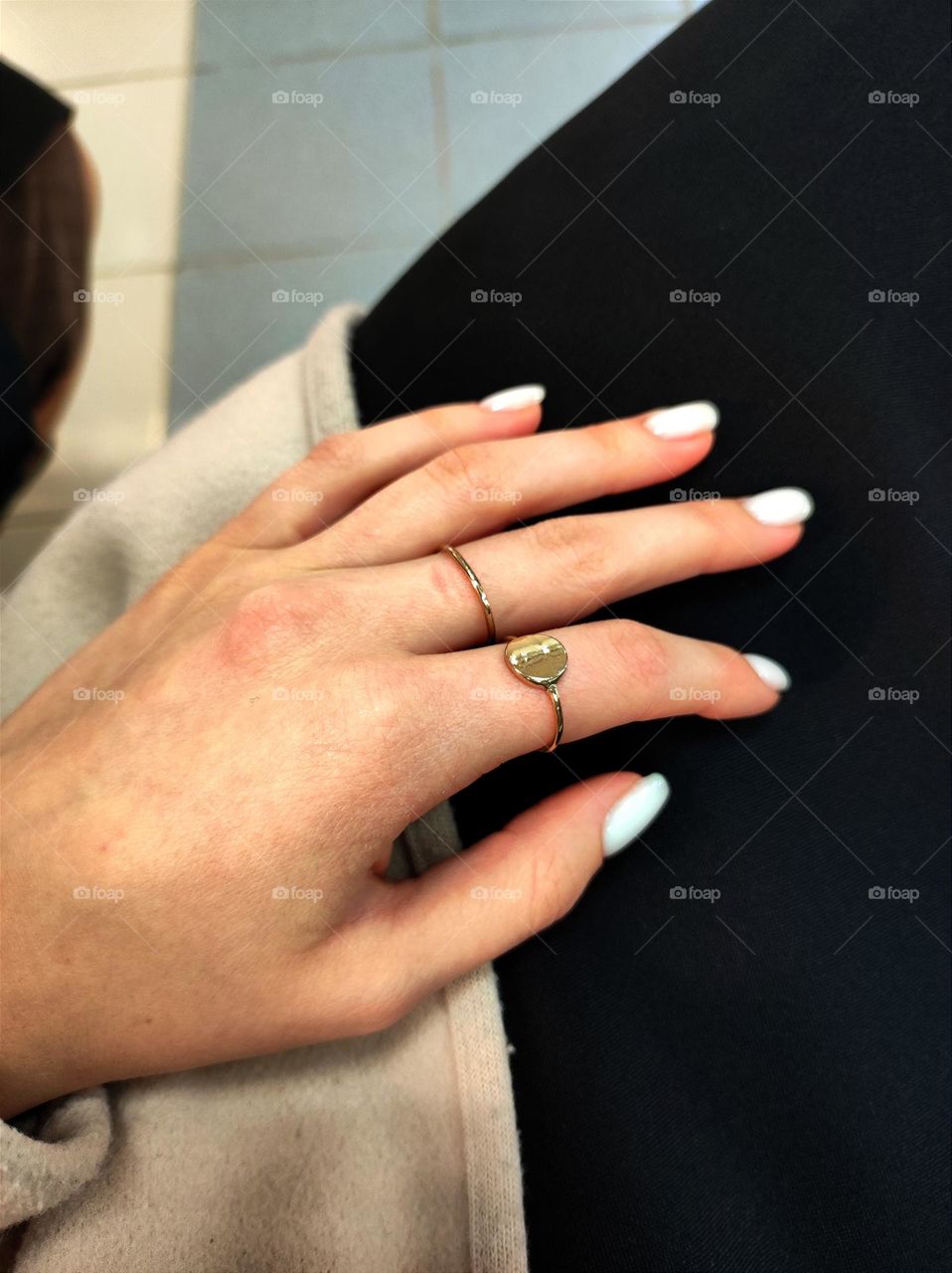 Wearing jewellery on a hand, simple golden rings on a manicured hand