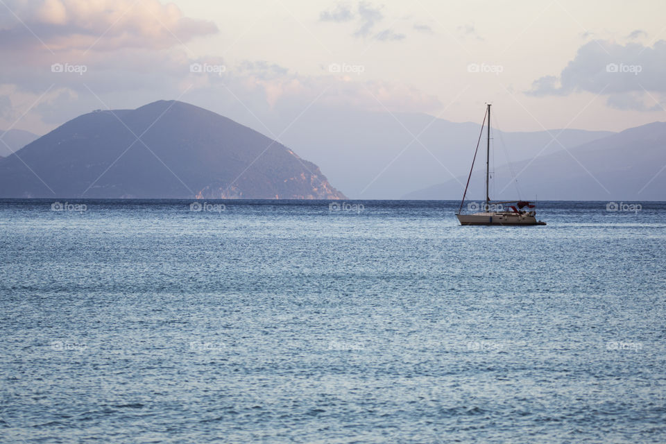 Small yacht sailing at dusk in Vassiliki, Lefkada