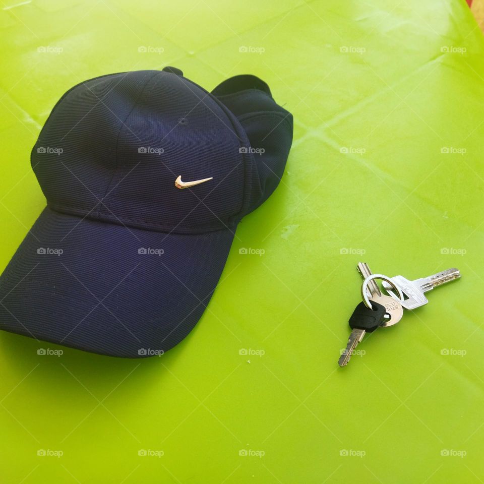 My blue hat and my keys on green table.