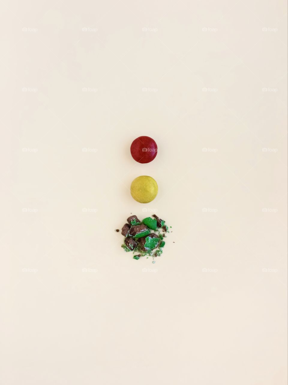 Red, yellow and green candies on beige background 