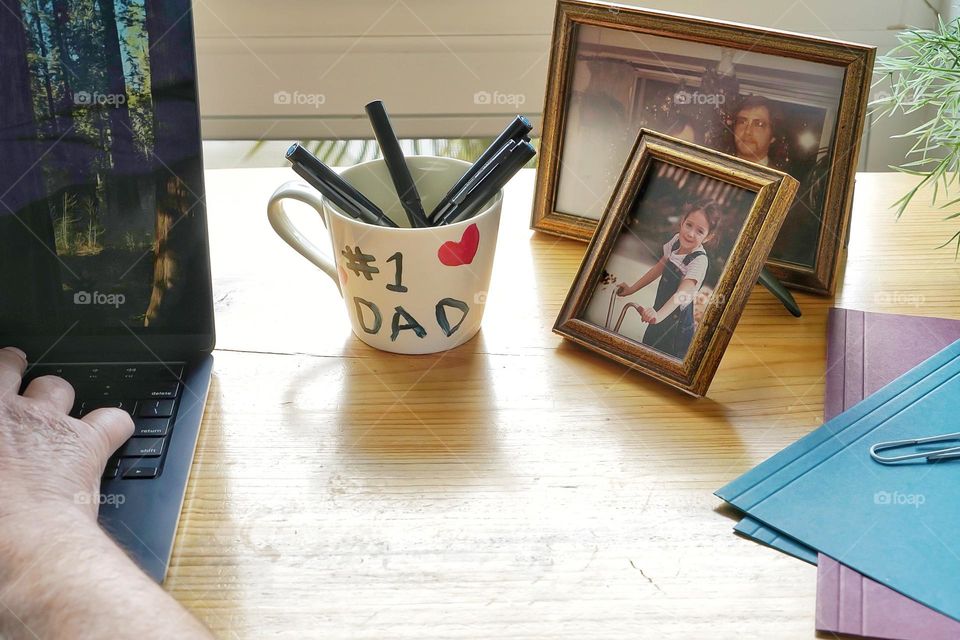 A father’s desk with homemade mug and family photos