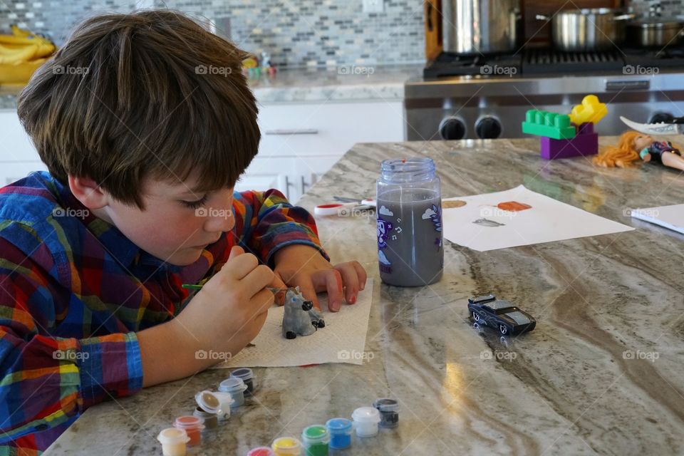 Young Artist Painting A Figurine