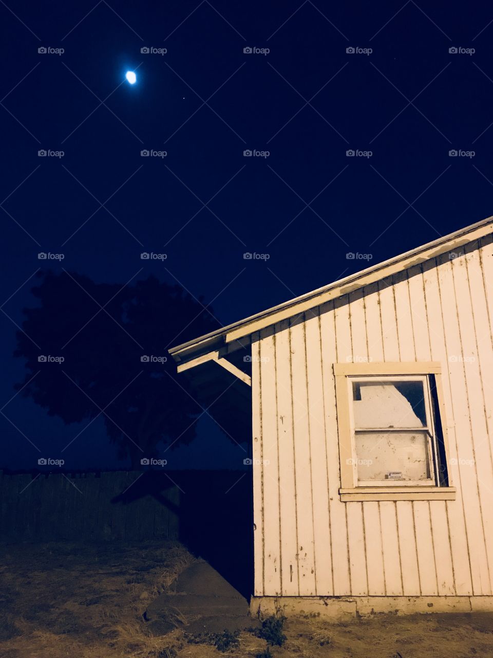The farmhouse at night under the moon and stars 