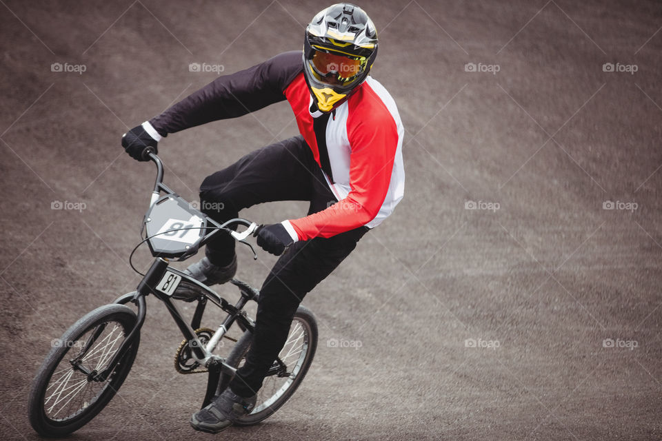 A person with helmet happily riding on bike