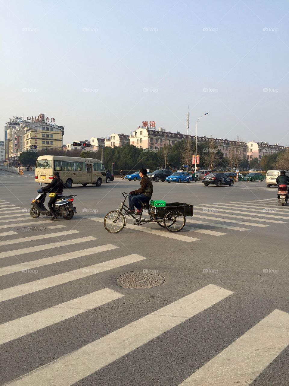 Drivers and cyclists on a road cross in China 