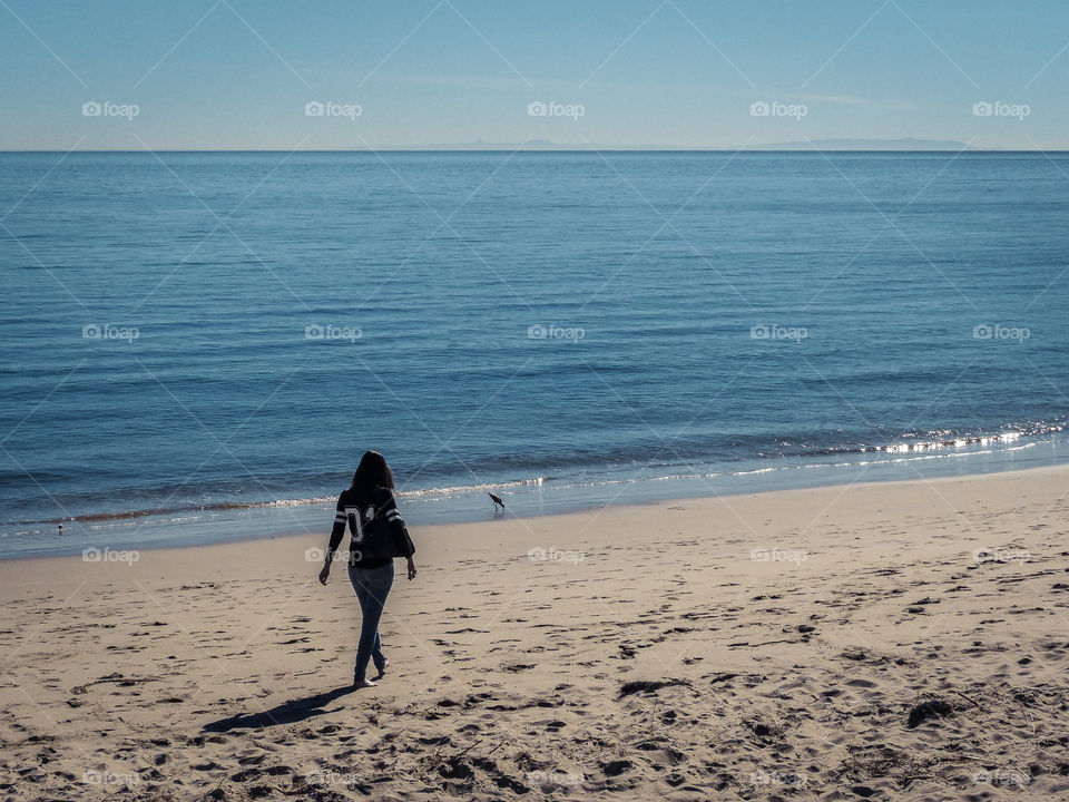 Girl walking on the beach in Malibu, California