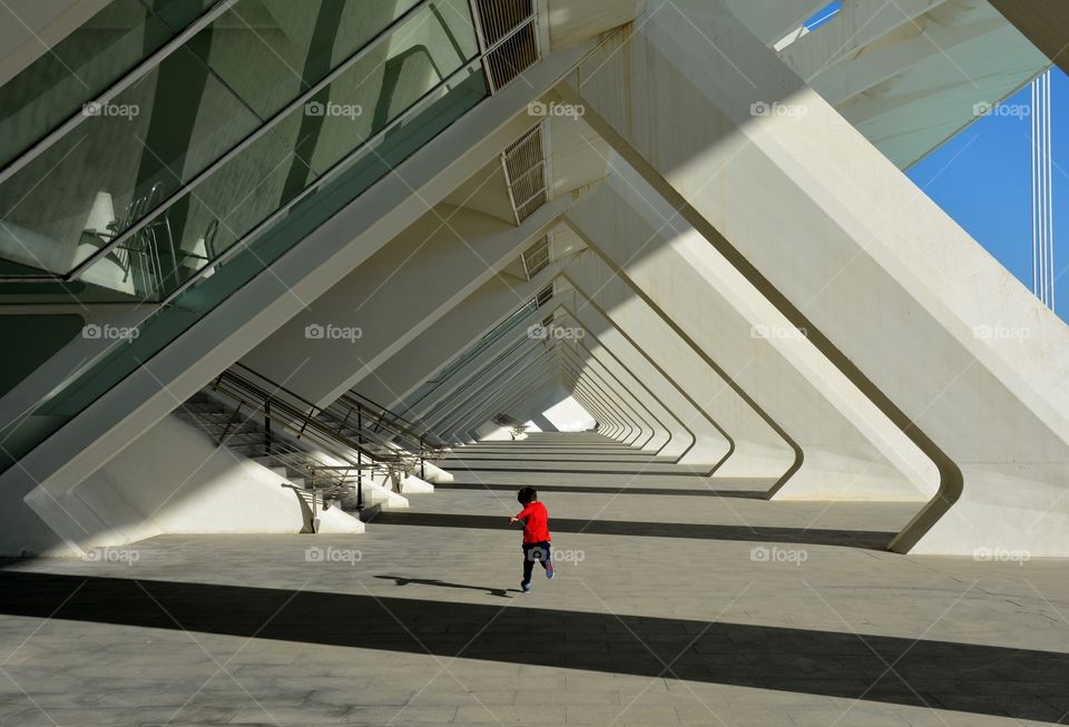 a boy running in a passage in a sunny day