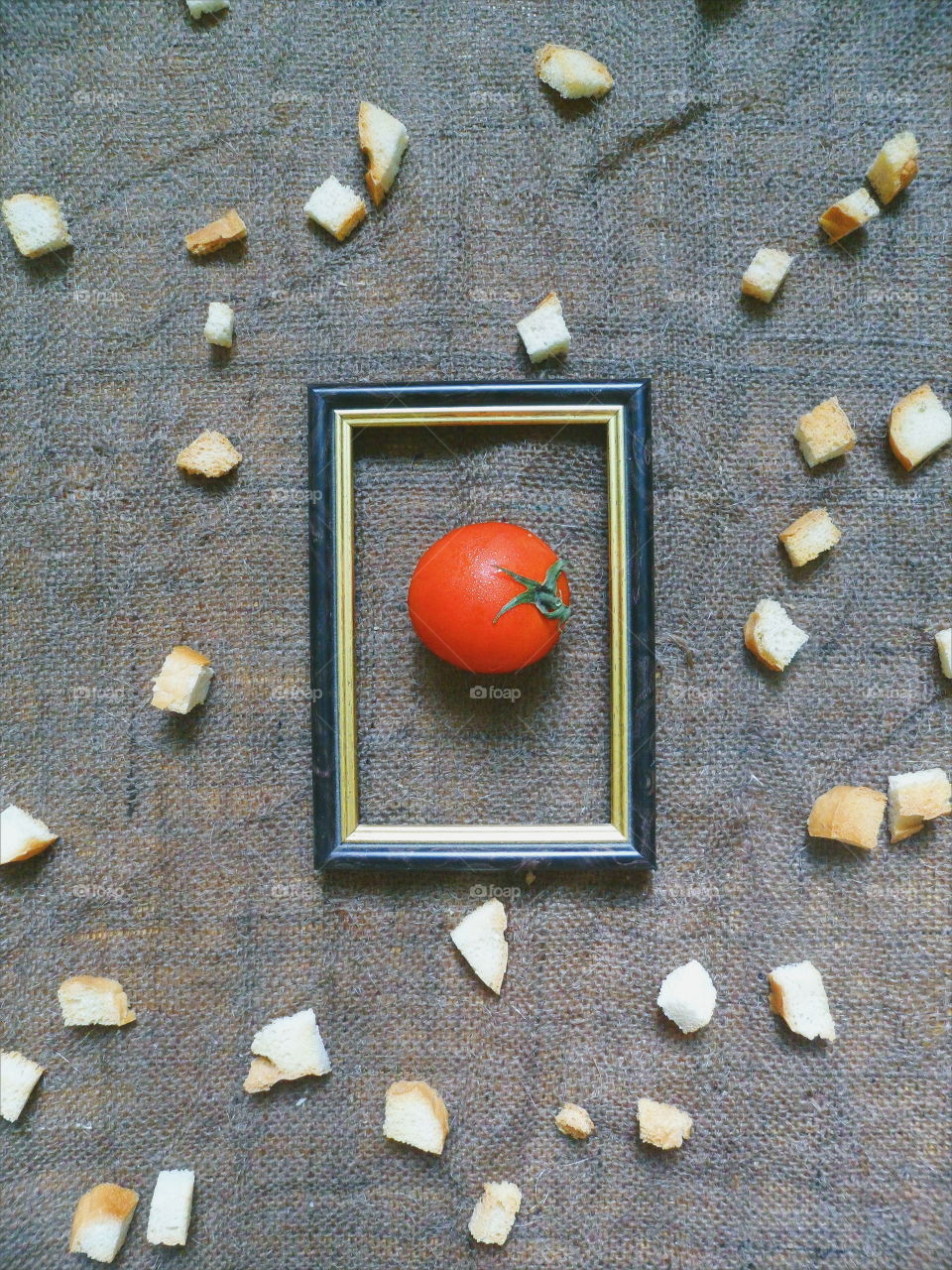 red tomato in a frame on a background of white crackers