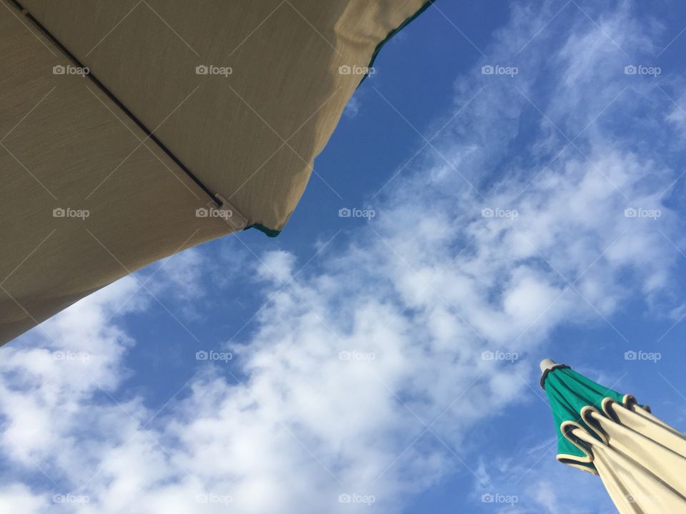 Umbrella beach on blue cloudy sky 