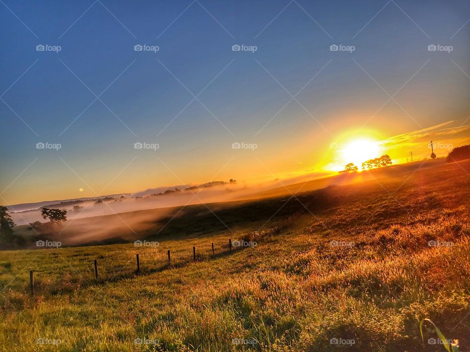 Fog over the fields as the sun appears