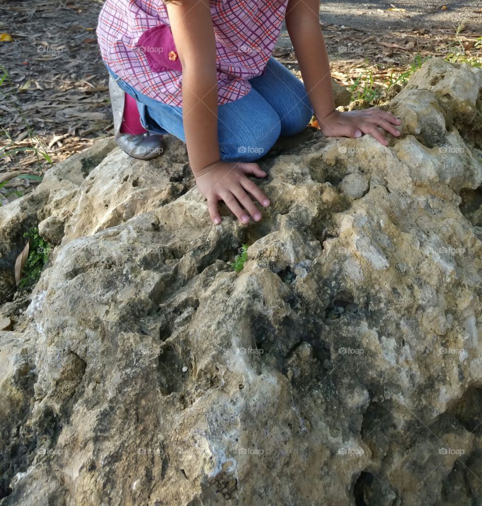 Girl playing on a rock