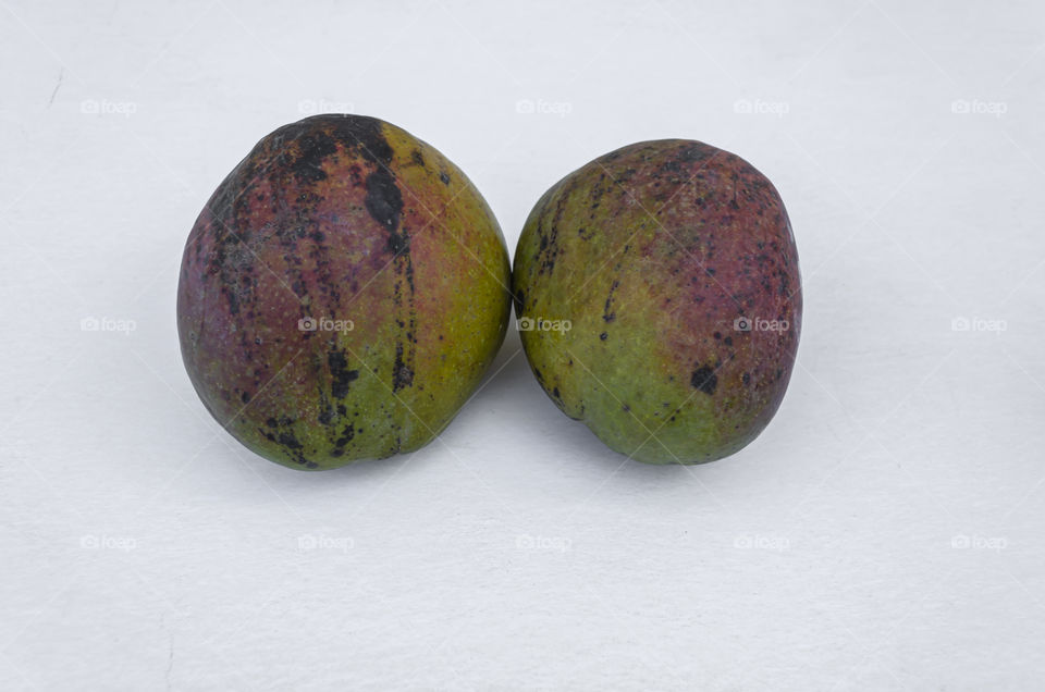Two Julie Mangoes On White Surface
